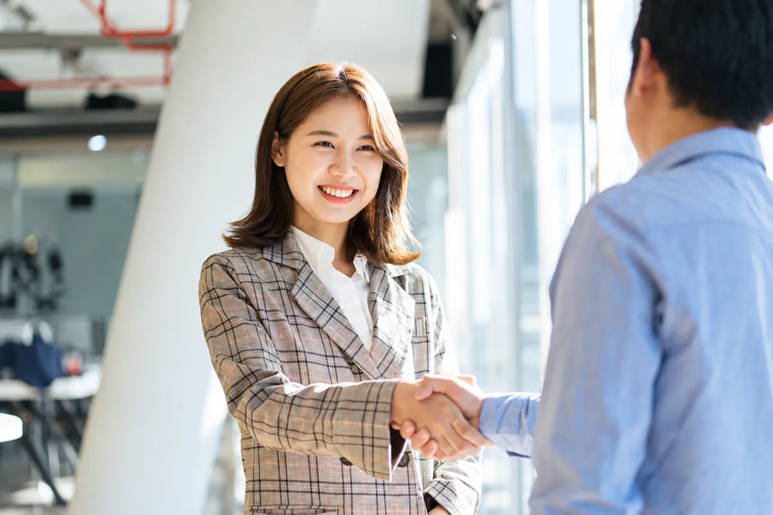 Two professionals shaking hands in an office