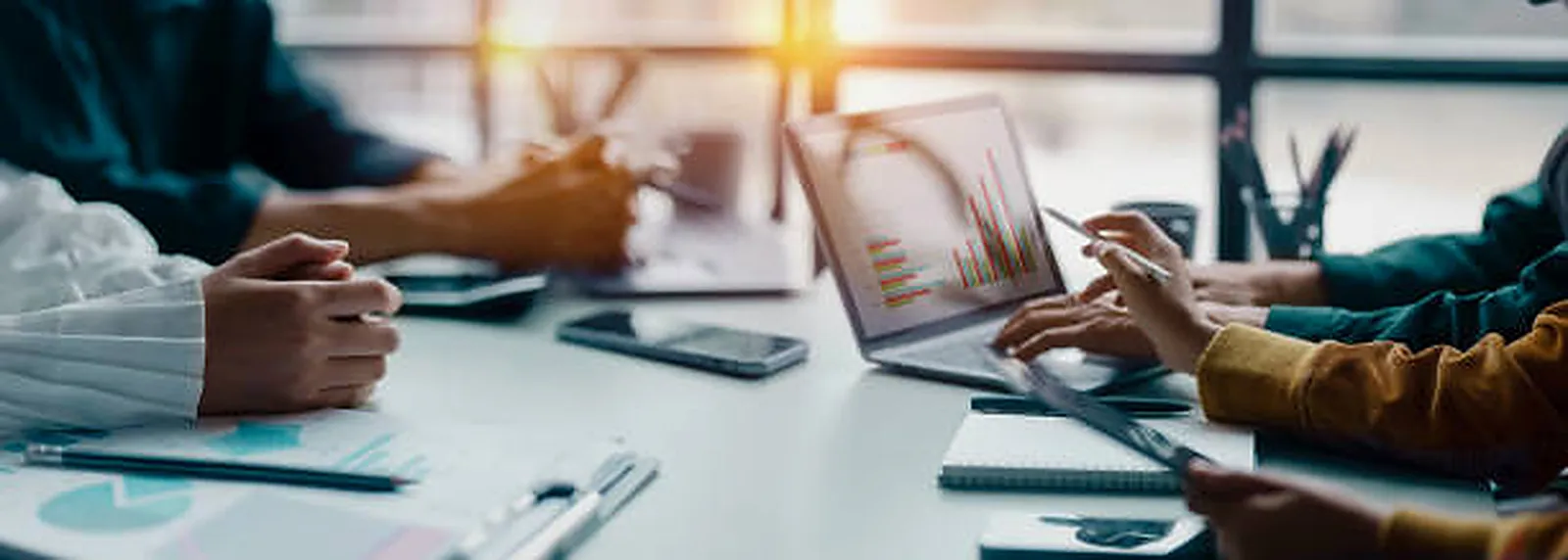 Hands reviewing printed reports beside a laptop