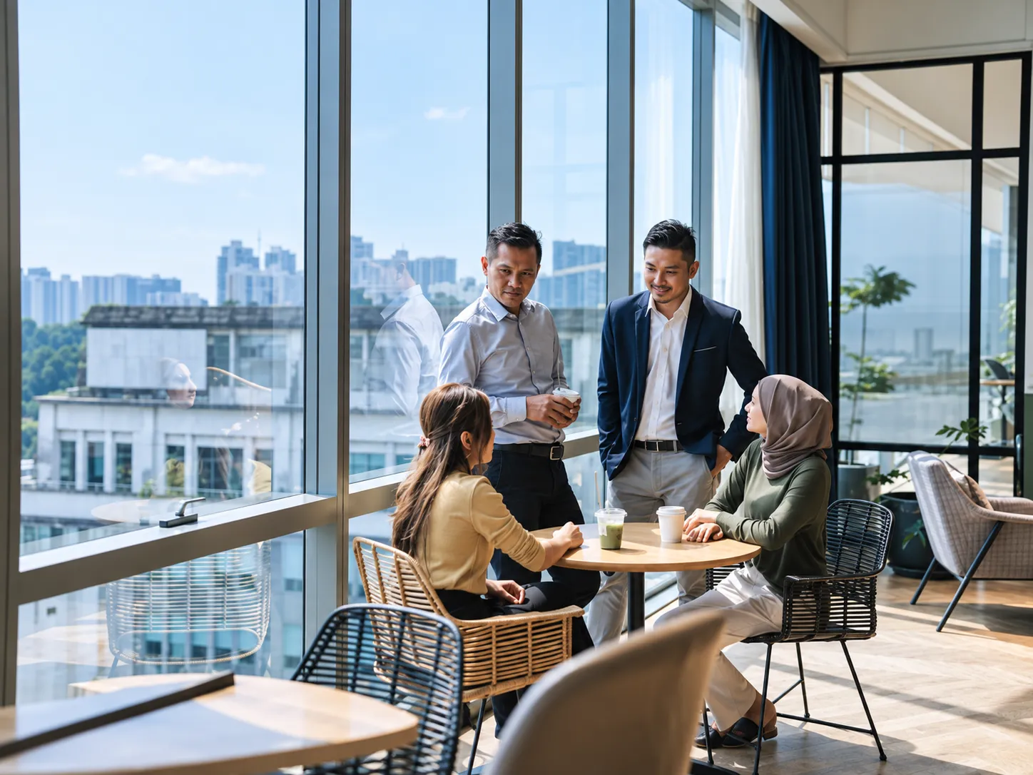 A business meeting beside large windows overlooking the city