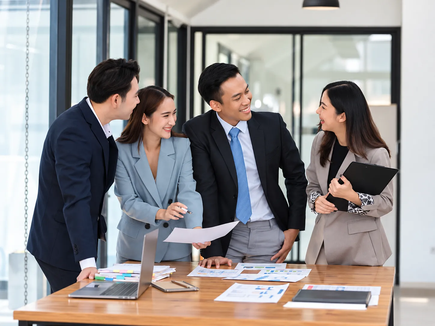 Four professionals discussing documents in an office