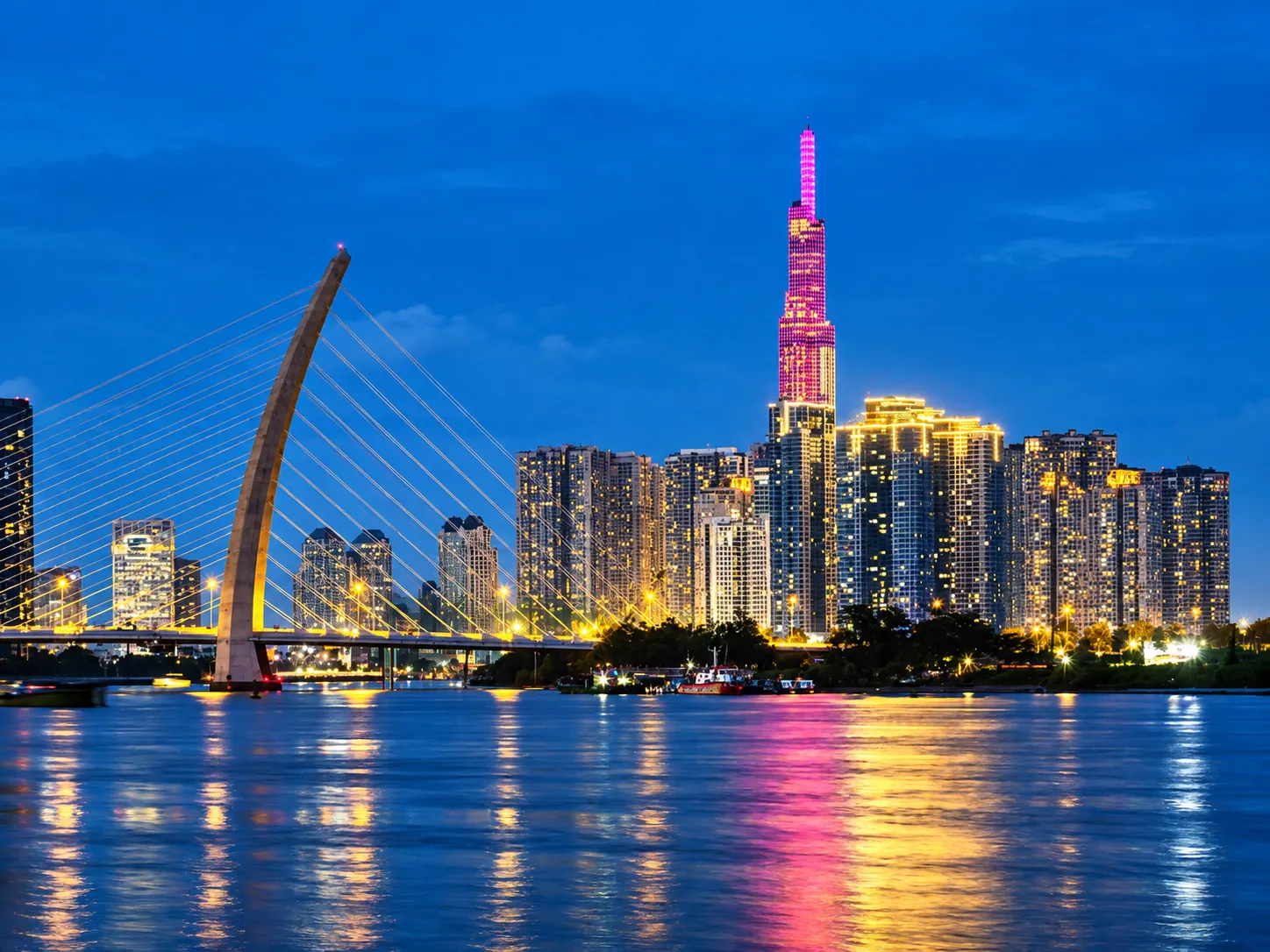 Ho Chi Minh City skyline and illuminated bridge across the river